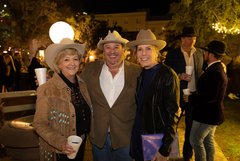 One man and two women in Alamo Gardens, all wearing cowboy hats
