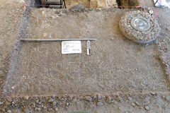 Top layer of excavation unit with a round stone feature at the corner