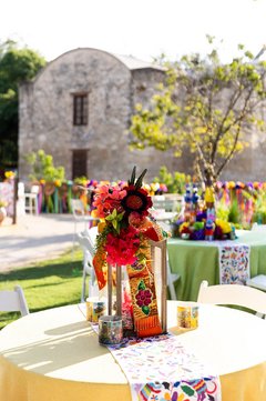 Cocktail table with yellow linen and colorful flowers in a garden