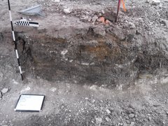 Excavation unit interior with small whiteboard on ground