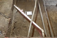 Crossed white pipes inside an excavation unit