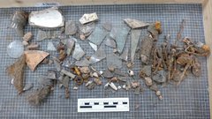 Artifact pieces over netting next to a ruler for size