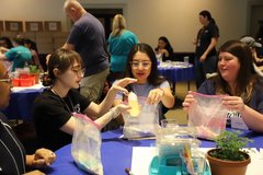 Teacher participants holding plastic bags in an interactive classroom demonstration