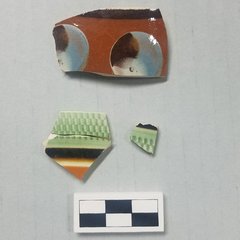 Ceramic sherds, the top with a tri-colored cat’s eye design