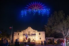 Drone lights over Alamo Church at night