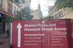 Red fence wrap on Houston Street with list of businesses in the area