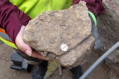 Large stone with a small shell button placed on top of it