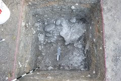 Inside of an excavation until with a marker at the bottom and pink ribbon in a square at the top perimeter