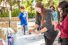 Students conducting experiment on a table in the courtyard.