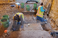 Excavations exposing vault and electrical line