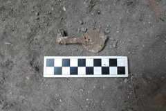 Key found in an excavation unit next to a ruler for size