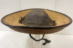 Palm leaf hat with leather crown on an acrylic holder