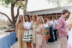 Four women smiling for the camera in Alamo Hall Patio