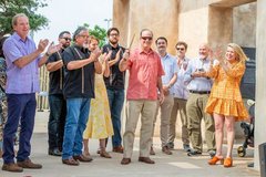 Man holding a Bowie knife post ribbon cutting surrounded by family members