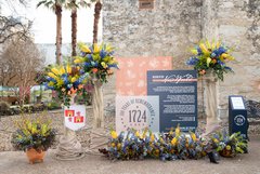 Columns and blue and yellow floral arrangements outside of Alamo Church