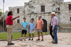 Tour guide with guests outside of Alamo Church