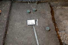 Smooth, dirt surface at bottom of excavation unit with pipe