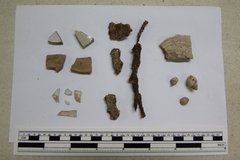 Variety of artifacts on white paper next to a ruler