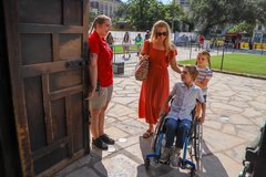 Boy in a wheelchair entering Alamo Church with his mother and sister