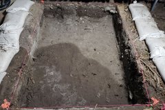 Dirt excavation area with white sandbags on both sides