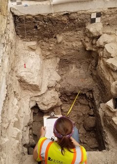 Archaeologist finding bedrock in excavation unit