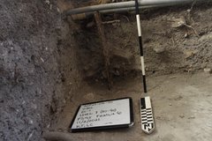 Inside of excavation unit with whiteboard and ruler to show depth