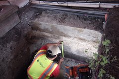 Archaeologist measuring the inside of an excavation unit