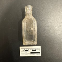 Glass bottle next to a ruler for size