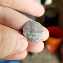Hand holding a round coin from 1841
