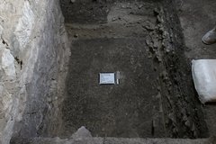 Whiteboard and marker at the bottom of a deep excavation unit