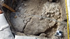 Curved stone footprint in excavation unit, facing south