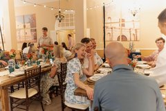Guests seated and laughing at a dinner event in Alamo Hall