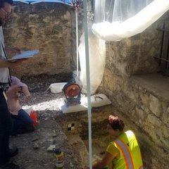 Archaeologists inside an excavation unit by the Long Barrack