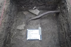 Inside of a square excavation unit with a white board inside