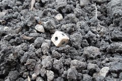 Gaming die on a bed of gravel