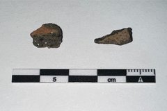 Two stone fragments next to a black and white ruler