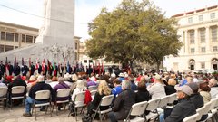 Guests seated listening to a speaker in front of the cenotaph