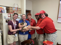 Bella being held by members of the visitor services staff