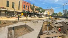 Construction workers setting pavers on Alamo Promenade