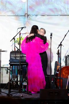 Kate Rogers and Shannon Ralston hugging on stage at an event