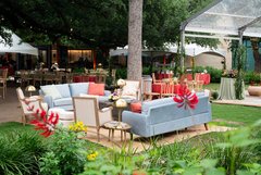 Blue and cream lounge seating set up outside tent in Alamo Gardens