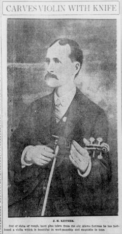 Man in a suit holding a violin