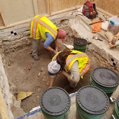 Two archaeologists inside an excavation unit