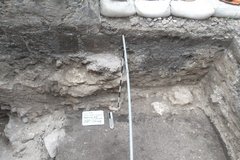 Inside of an excavation unit with a pipe down the center as a divider