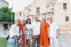 A group posing in front of Alamo Church