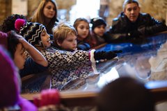 Students on a field trip discover more about the Alamo from a model inside the Church.