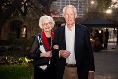 Woman and a men arm in arm as they enter an event