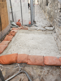 Sandbags surround completed backfilling in excavation unit