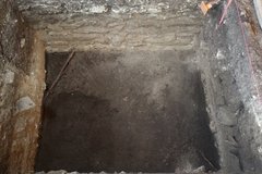 Dark dirt surface at the bottom of an excavation unit