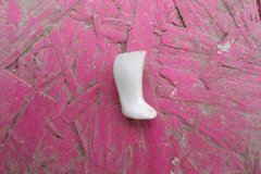 White figurine leg on a pink background